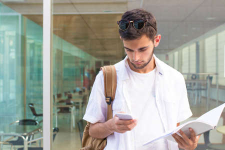 student with mobile phone on the university campusの写真素材
