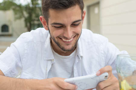 young or young adult smiling with the outdoor mobile phone in the cafeteria