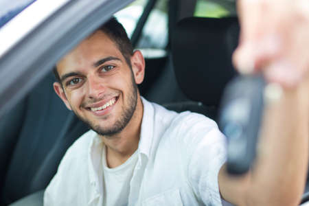 young smiling with the keys in the car window