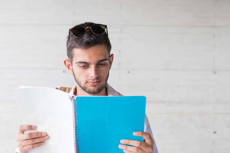 student studying with open notebook on wall background