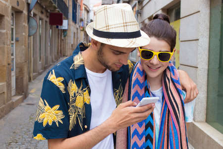 friends watching the mobile phone on the streetの写真素材