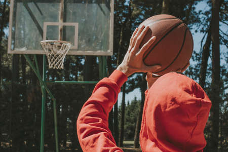 young man with basketball ball throwing basketの写真素材