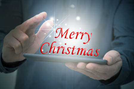 hands with tablet or computer and merry christmasの写真素材
