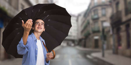 young with umbrella in town watching if it rainsの写真素材