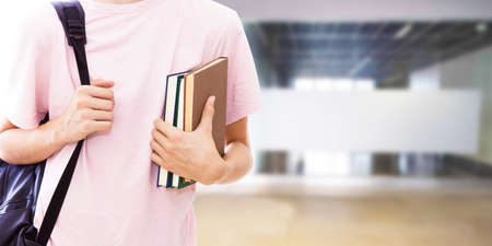 student hand with books and college or university backgroundの写真素材