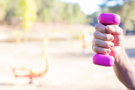 older adult hand with gym or fitness dumbbellの写真素材