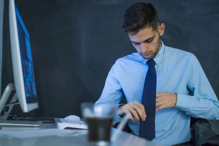 businessman in the office putting tieの写真素材