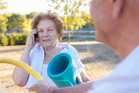 elderly woman with mobile phone doing outdoor sportsの写真素材