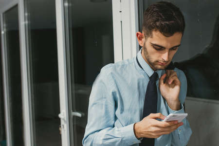 businessman typing on the mobile phone in the office