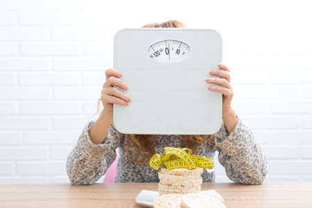 diet and slimming concept, corn cakes with tape measure and girlの写真素材