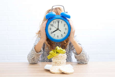 diet and slimming concept, corn cakes with tape measure and girl