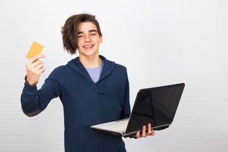 young or child isolated with laptop and credit card