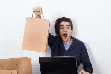 young with computer and shopping bags, online purchases