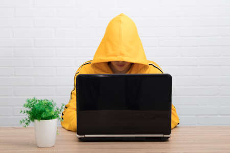 hidden young man typing in the computerの写真素材