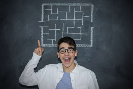 portrait of young man with glasses and labyrinth drawn on the slate