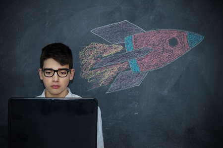 child with laptop and spacecraft or rocket