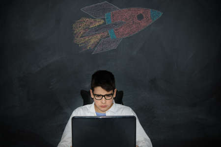student with computer and spacecraft or rocket