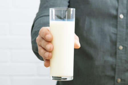 hand with glass of fresh milkの写真素材