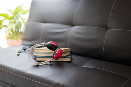 books and headphones on the home sofaの写真素材