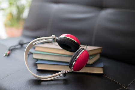 books and headphones on the home sofaの写真素材