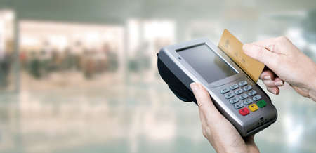 hand paying with credit card and store backgroundの写真素材