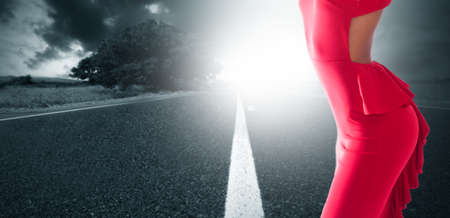 slender woman silhouette of red suit on the roadの写真素材