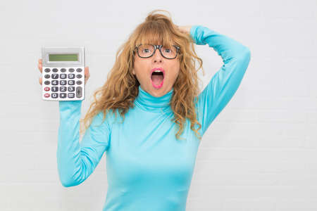 isolated adult woman with calculator and expression of surpriseの写真素材