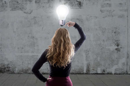 woman thinking with the light bulb onの写真素材