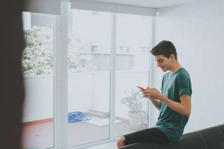 young or teen at home with mobile phone