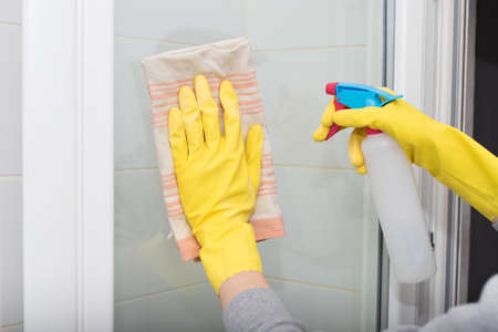hand with cloth and spray cleaning