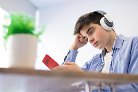 young teenager with phone and headphones