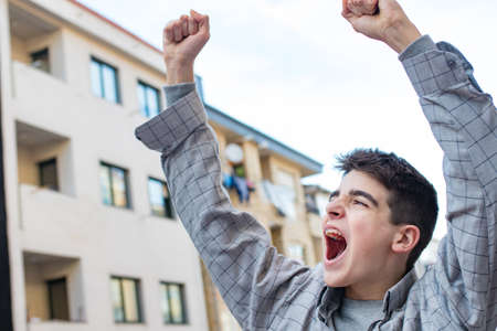 teen or student screaming and celebrating outdoorsの写真素材