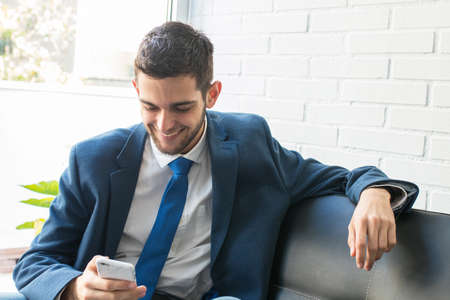 business man with mobile phone on the couch