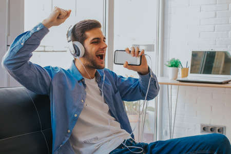 man with mobile phone and singing headphones