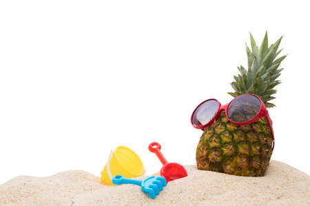 pineapple with sunglasses on the sand of the beachの写真素材