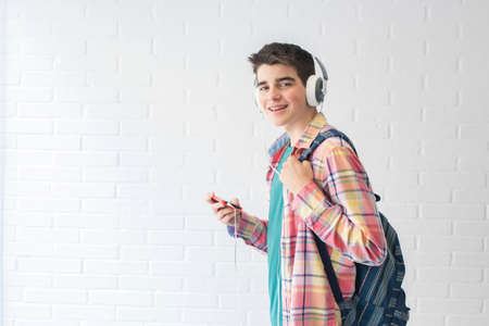 student with backpack, mobile phone and earphones listening music