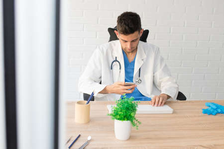 doctor with the cell phone at the desk or clinicの写真素材