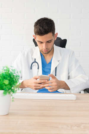 doctor with the cell phone at the desk or clinicの写真素材