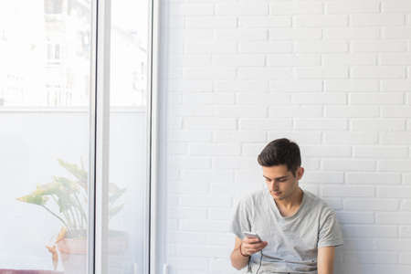 young at home with mobile phone