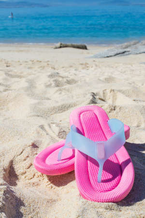 sandals in the sand of the beachの写真素材