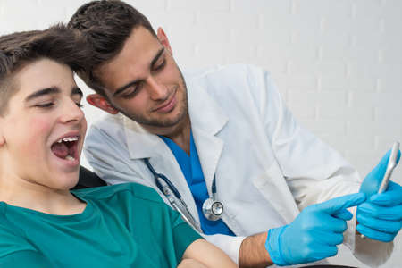 dentist showing the patient on the mobile phone