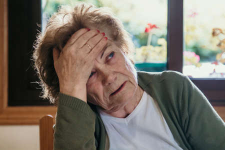 portrait of an older woman with a headache expressionの写真素材