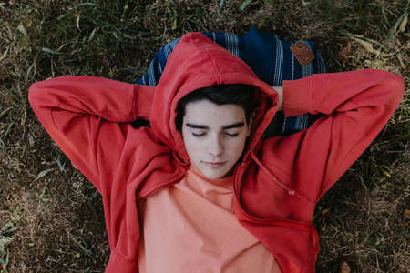 young or teenage student lying in the fieldの写真素材