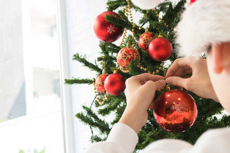 closeup of child hands decorating the christmas treeの写真素材