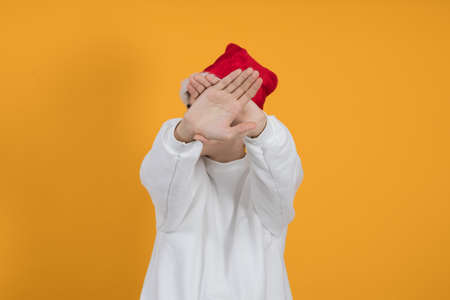 young teenage man wearing santa claus hat and color backgroundの写真素材