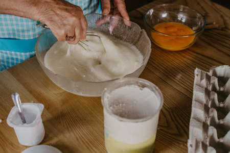 adult woman in the kitchen kneading the mix for sweets and desserts