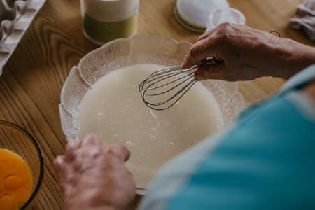 adult woman in the kitchen kneading the mix for sweets and desserts