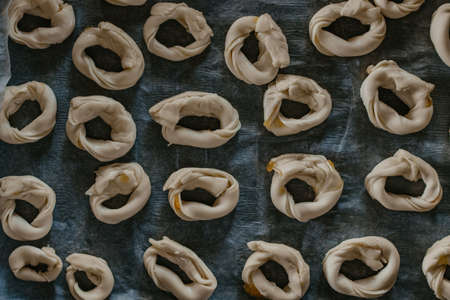 cookies or donut-shaped sweets on the tray prepared for cookingの写真素材