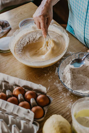 adult woman in the kitchen kneading the mix for sweets and dessertsの写真素材