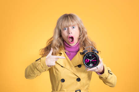 adult woman with alarm clock or alarm isolated on color background